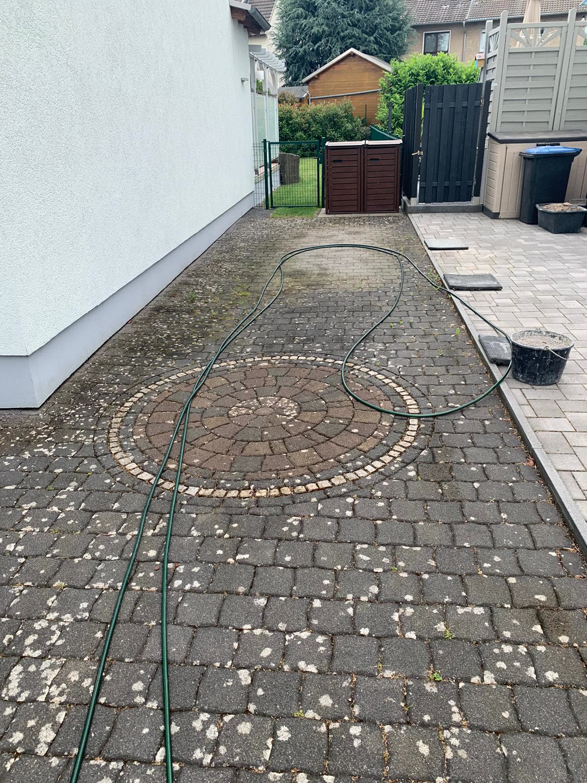 Verschmutztes Betonpflaster mit Ornamentkreis vor der Reinigung