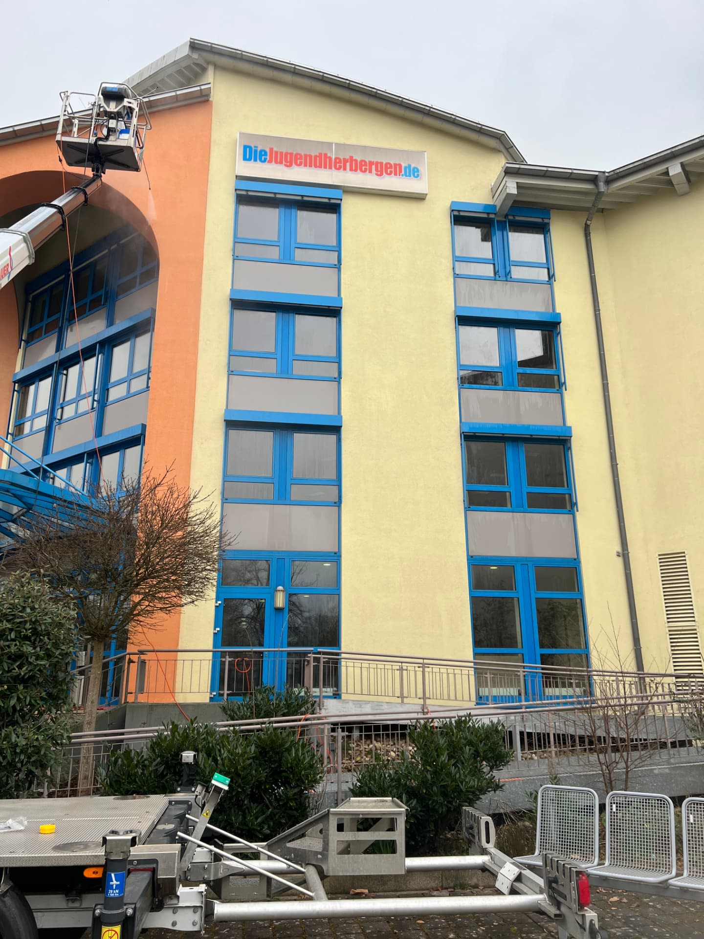 Hebebühne an der Putzfassade der Jugendherberge Bad Homburg während der Fassadenreinigung