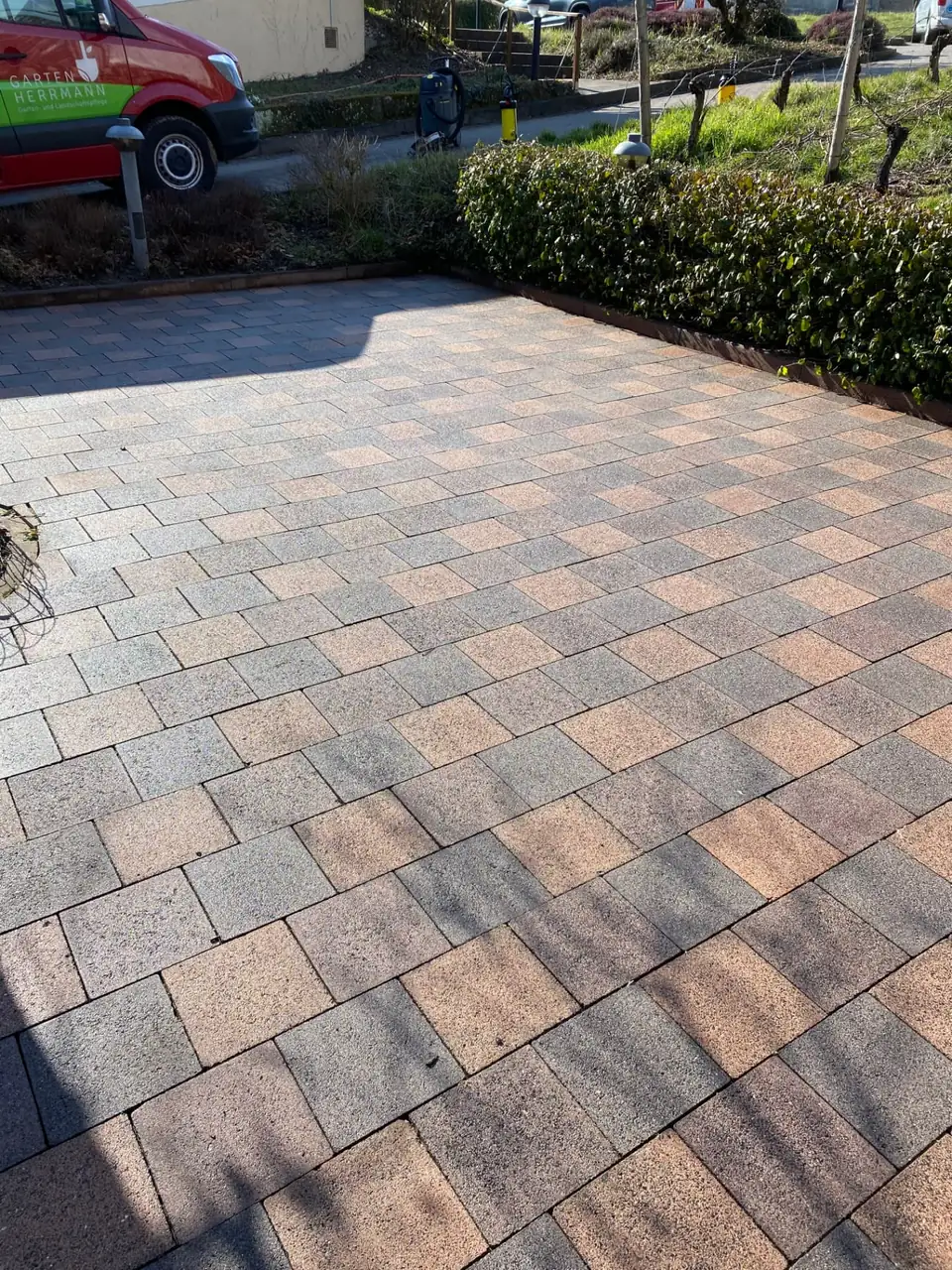 Gereinigter Plattenbelag mit sichtbarer Farbe des Steins und Servicefahrzeug im Hintergrund