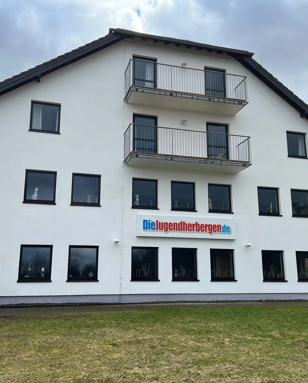 Gereinigte, gleichmäßig weiße Giebelfassade der Jugendherberge Tholey nach der Fassadenreinigung