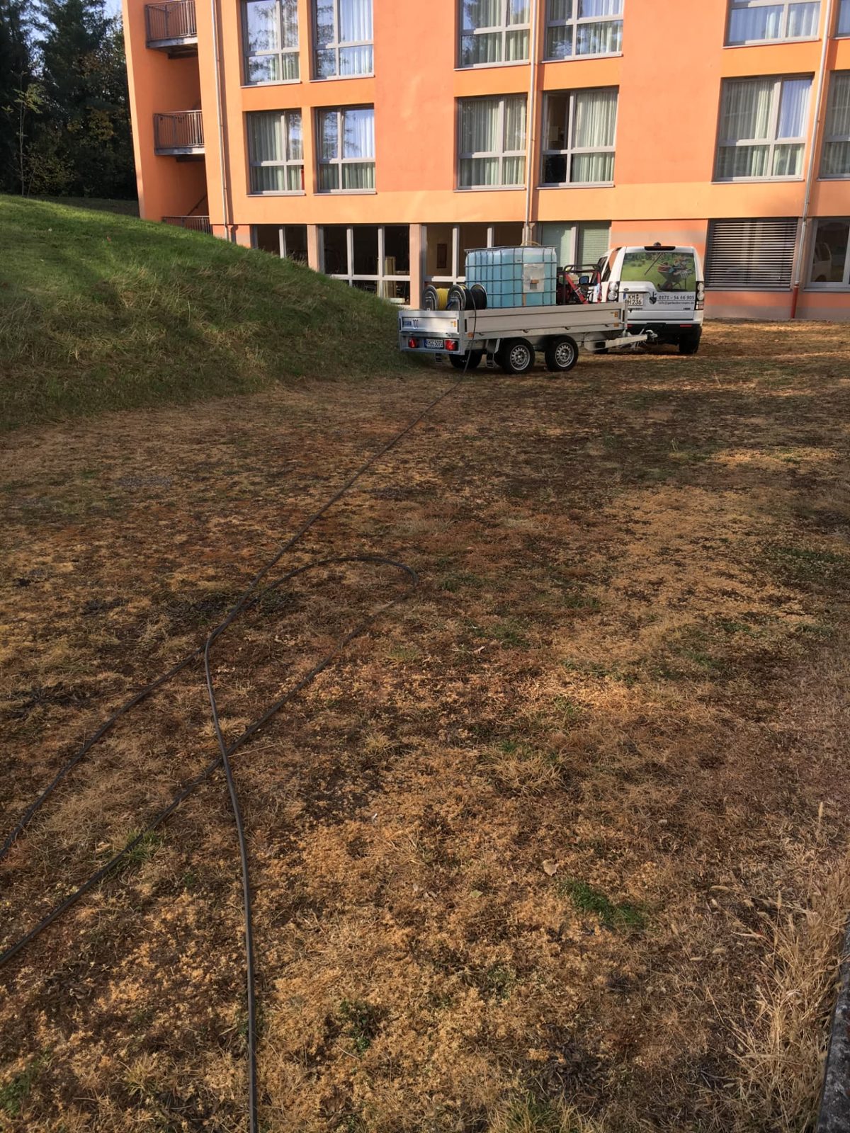 Servicefahrzeug mit Wassertank und Heißwasseraggregat an einer behandelten Fläche