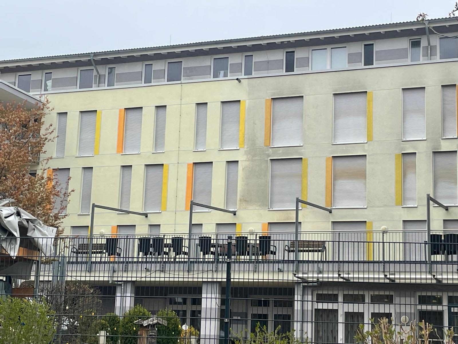 Fassadenfeld des Seniorenheims mit deutlichem Grau- und Algenbelag vor der Reinigung