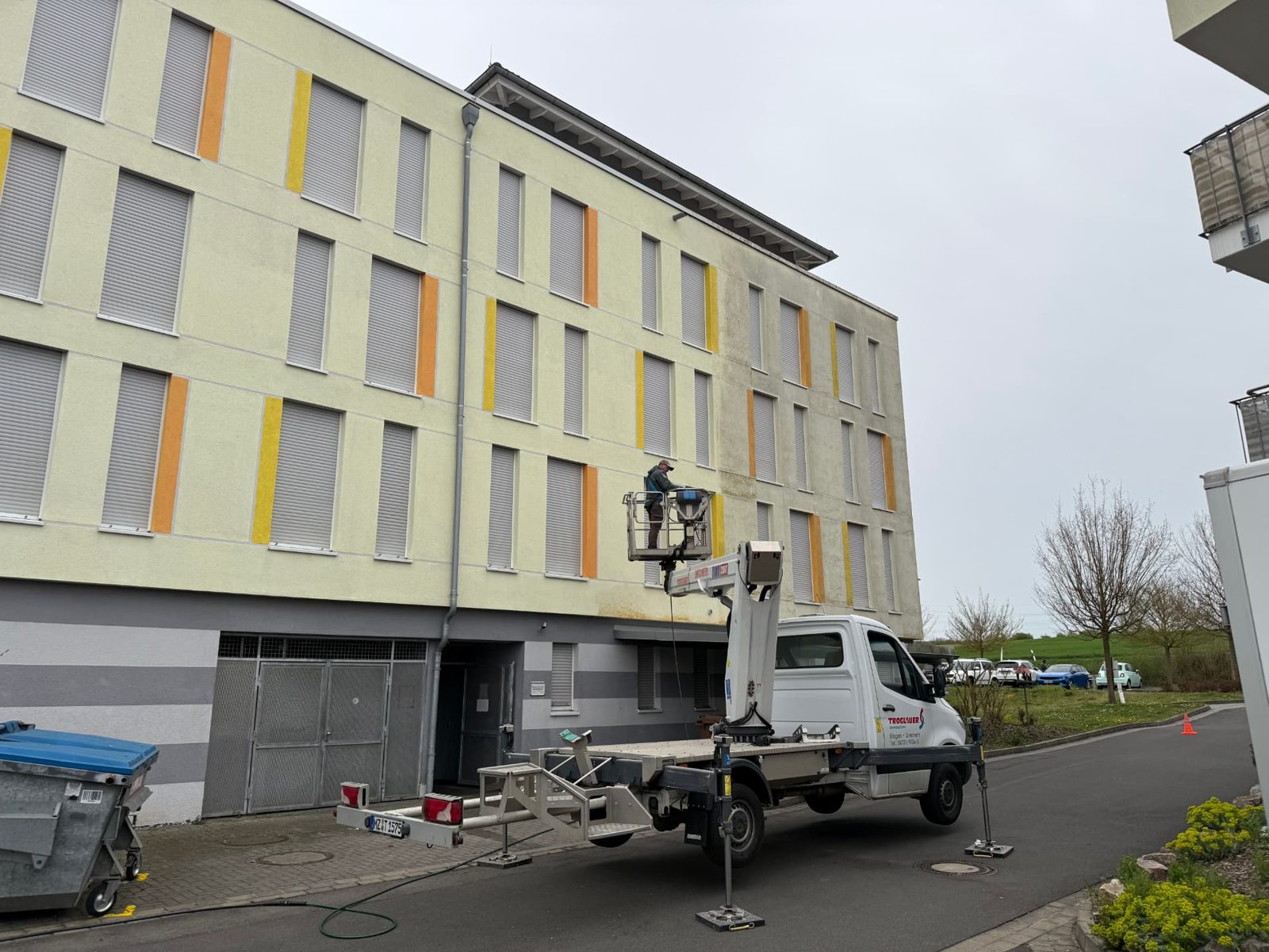 Arbeitsbühne an der Längsfassade des Seniorenheims, gereinigte und ungereinigte Fläche im Vergleich