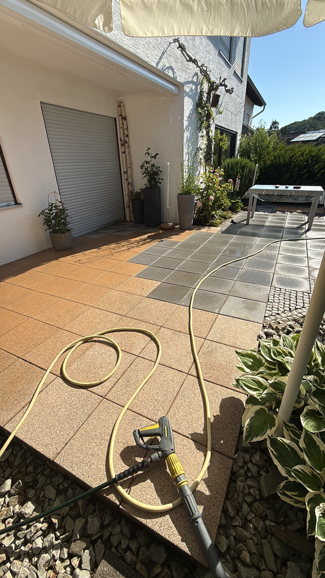 Fertig gereinigte Terrassenfläche mit Waschbetonplatten am Wohnhaus