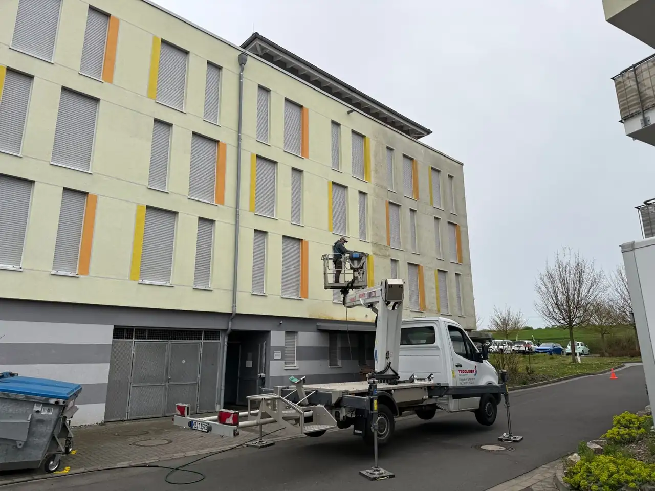 Arbeitsbühne an der Längsfassade des Seniorenheims, gereinigte und ungereinigte Fläche im Vergleich