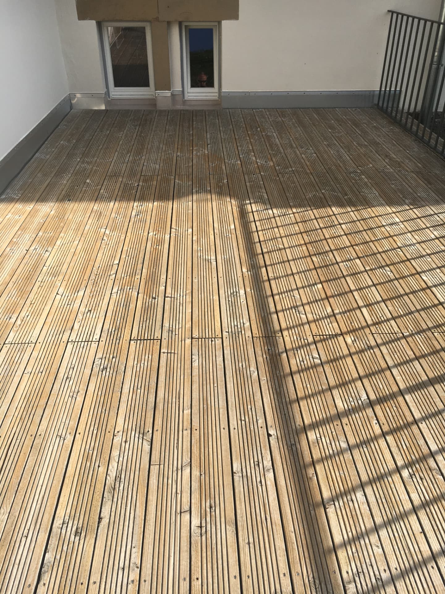 Ausgegraute Holzterrasse mit verwittertem Belag vor der Reinigung