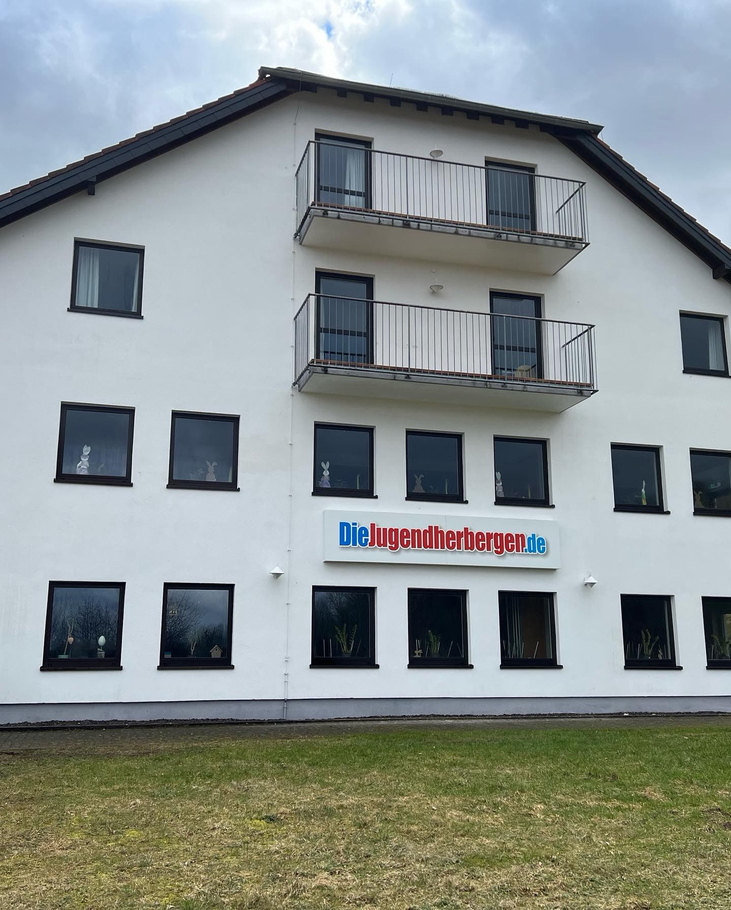 Gereinigte, gleichmäßig weiße Giebelfassade der Jugendherberge Tholey nach der Fassadenreinigung